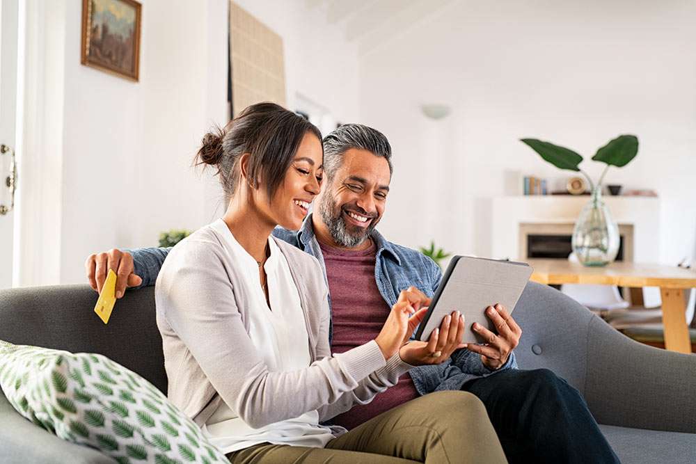 Happy couple using tablet for patient self-scheduling appointments