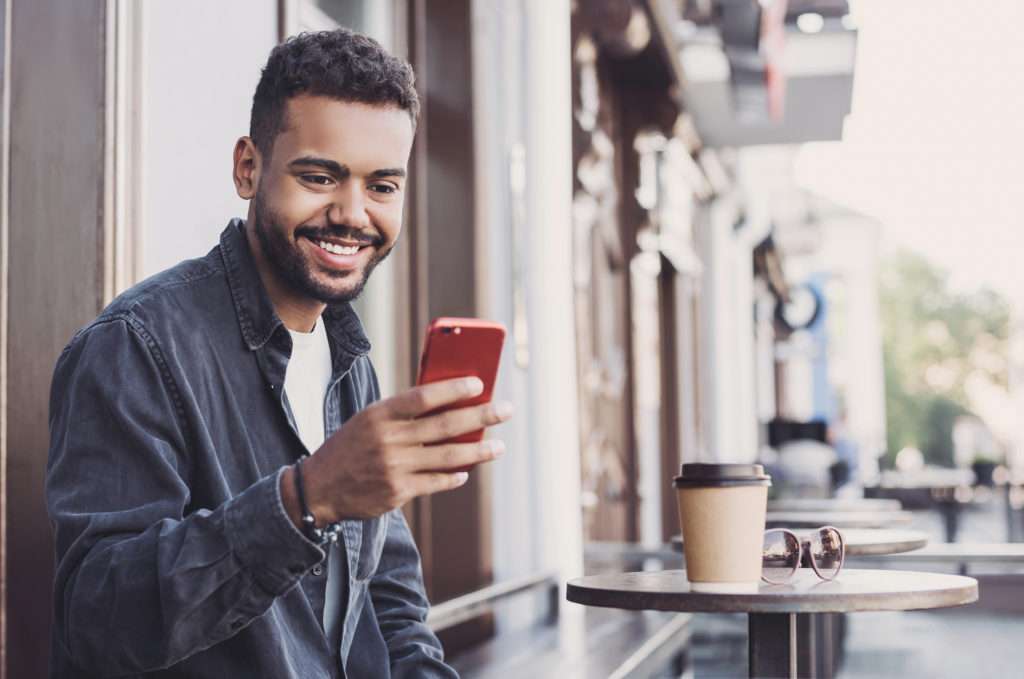 Handsome man using smartphone using healthcare scheduling software systems