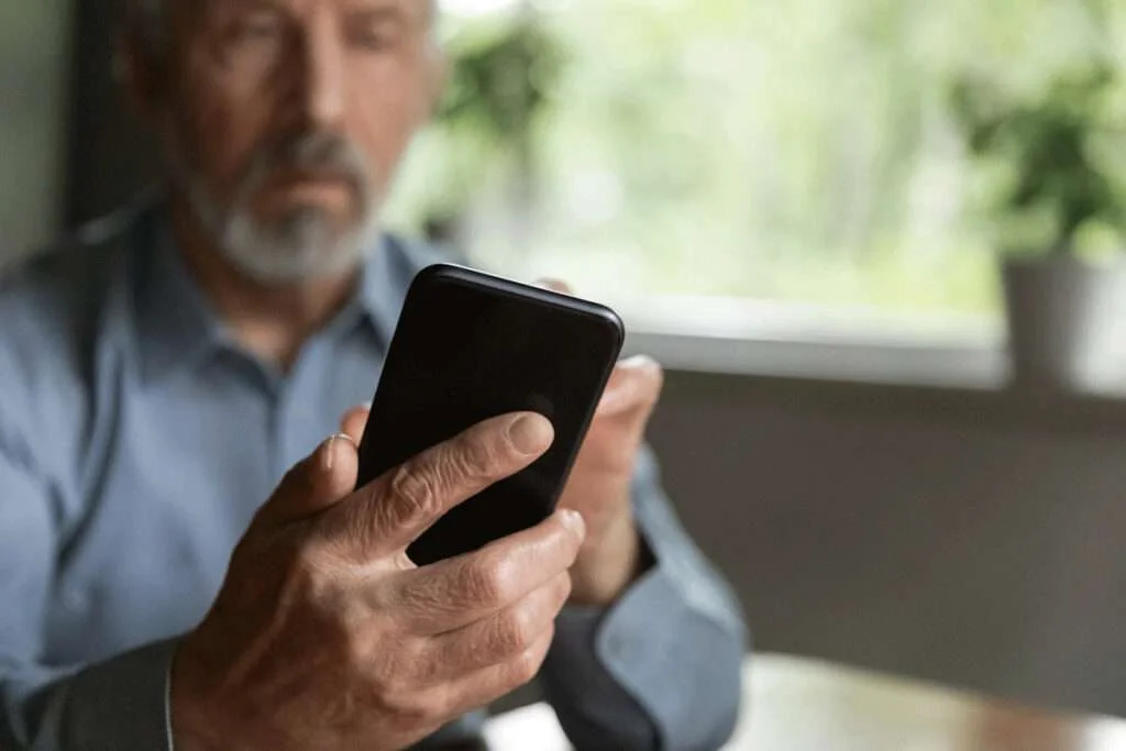 middle aged man using mobile phone to schedule patient appointment