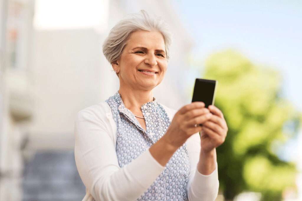 senior woman holding smart phone using dash chat to text with healthcare provider