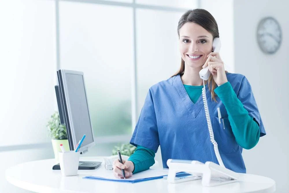 Female healthcare scheduler engaged in patient phone appointments