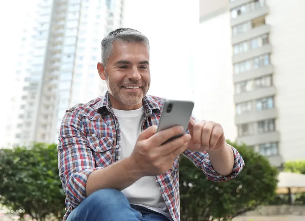 man looking at phone while Optimizing Patient Scheduling