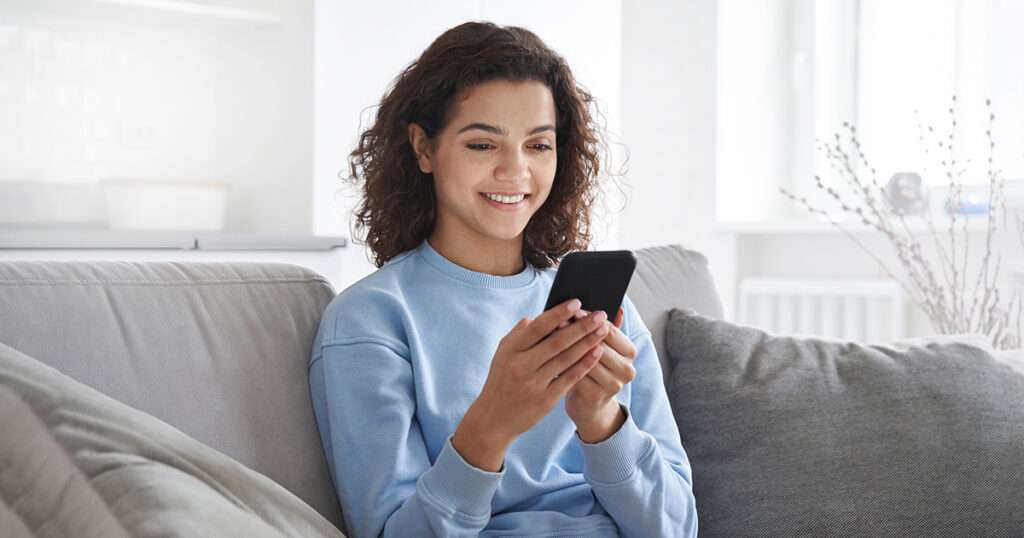 woman smiling holding smartphone using dash chat with doctors office