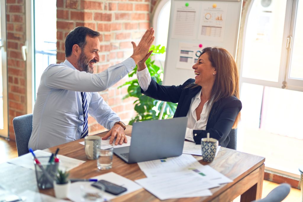 Young professional couple celebrating healthcare messaging system