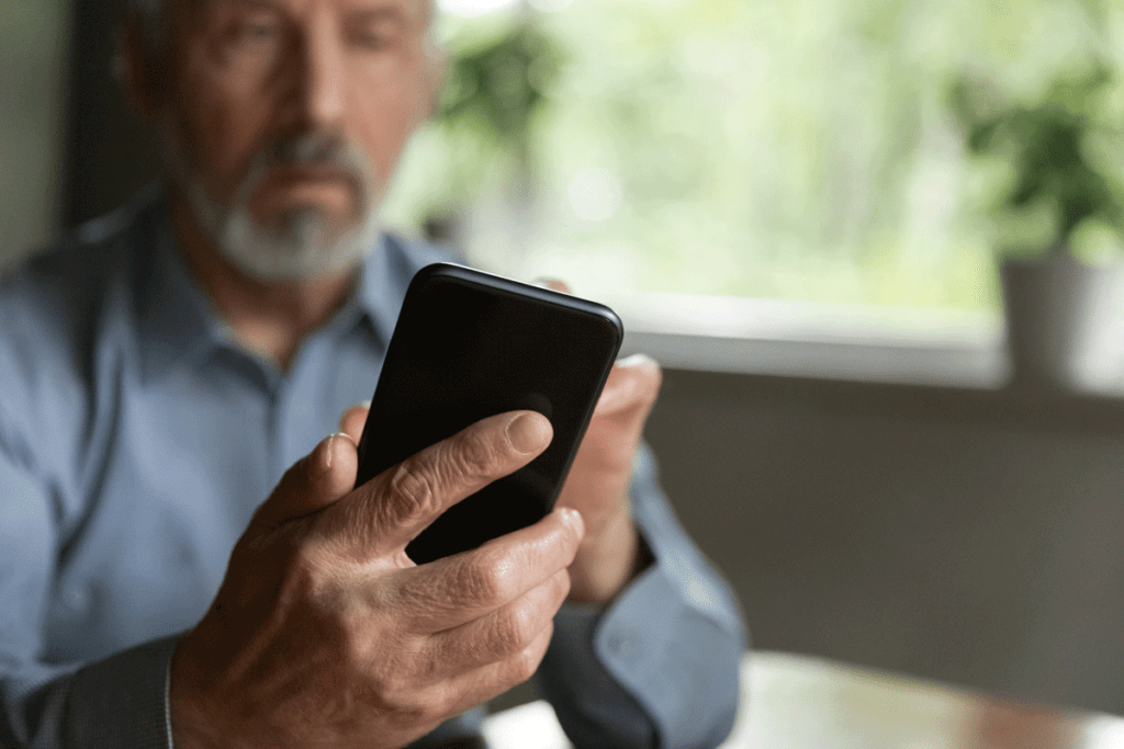 senior man receiving medical appointment reminder on mobile phone