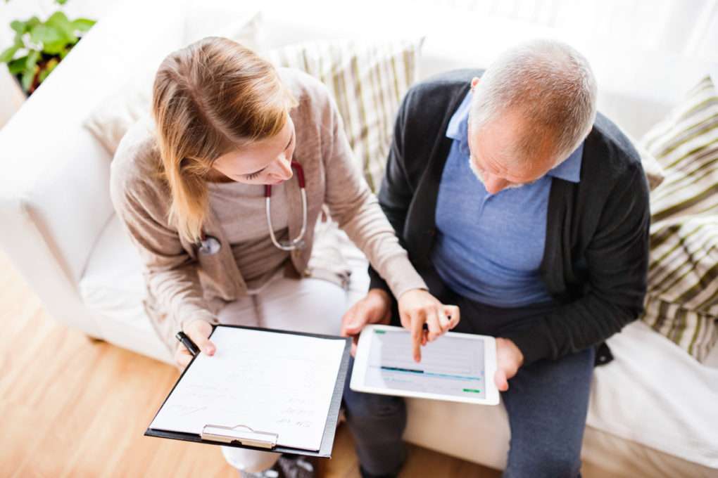 doctor showing older man how to use online appointment self scheduling