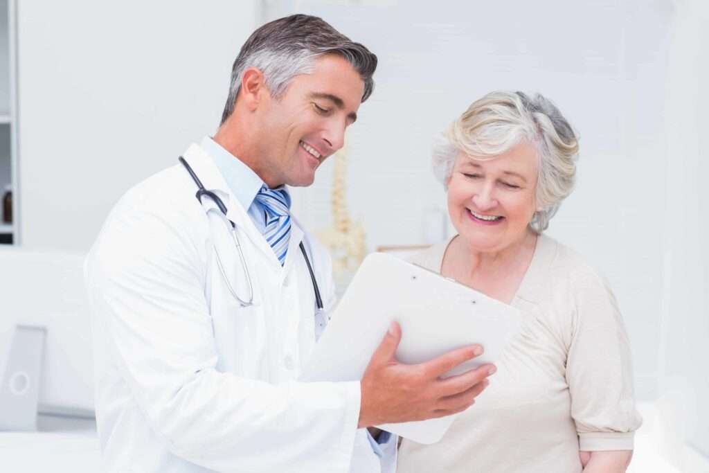 doctor explaining Patient Intake Software to senior woman