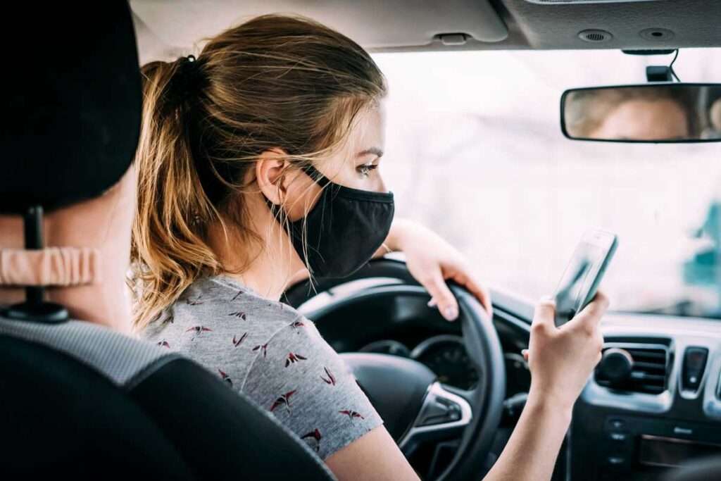 masked woman using smart phone for patient scheduling software for healthcare