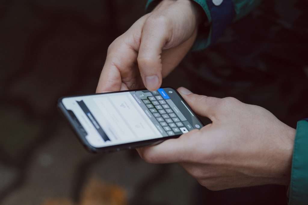 individual using cell phone with patient self scheduling software installed