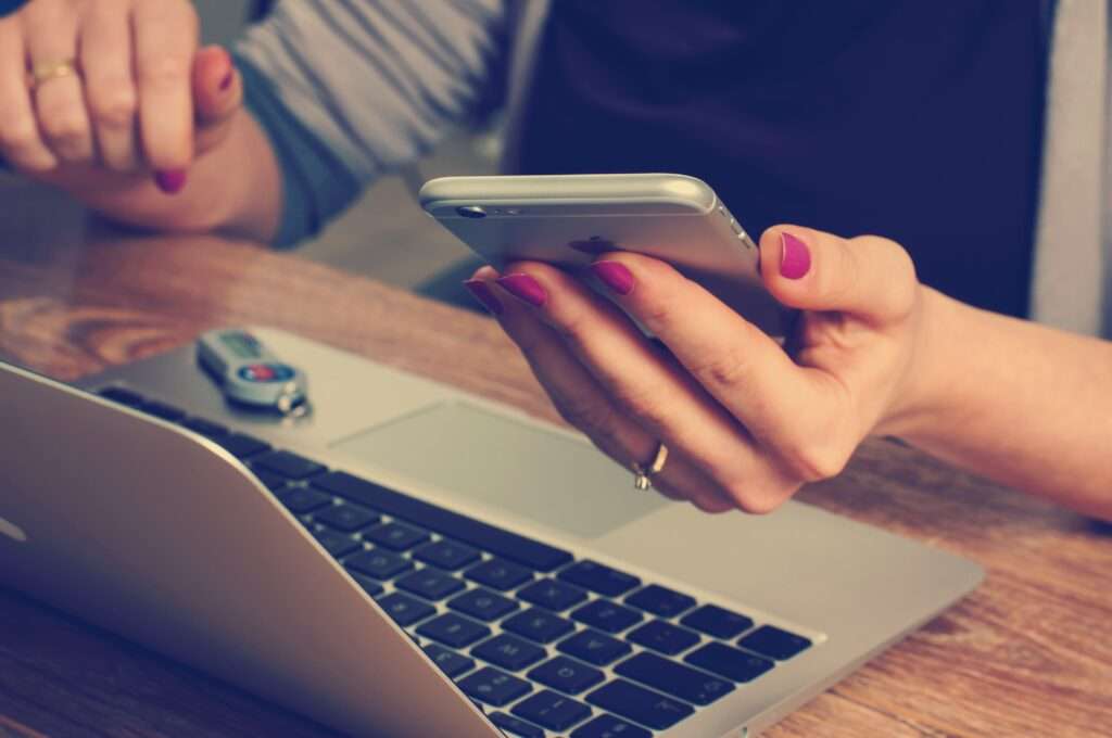 woman using laptop and mobile for patient engagement platform