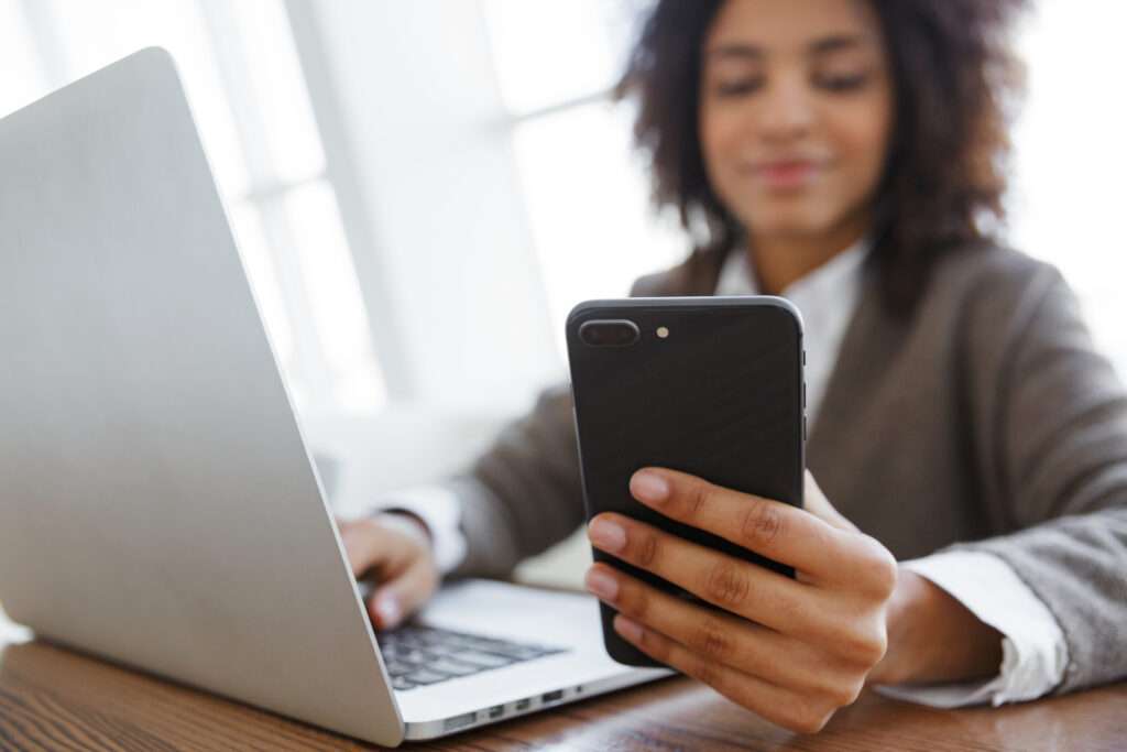 African American woman using mobile phone for patient self scheduling appointment