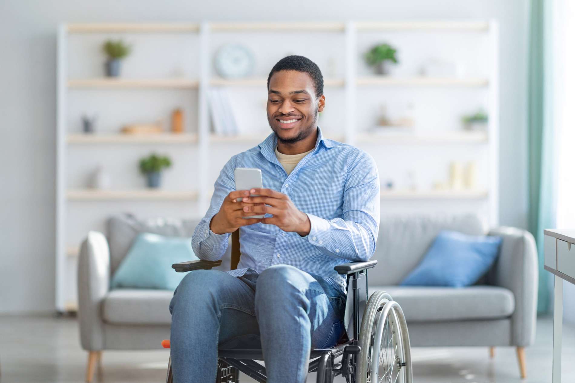 african american man in wheelchair using mobile phone engaging with healthcare software