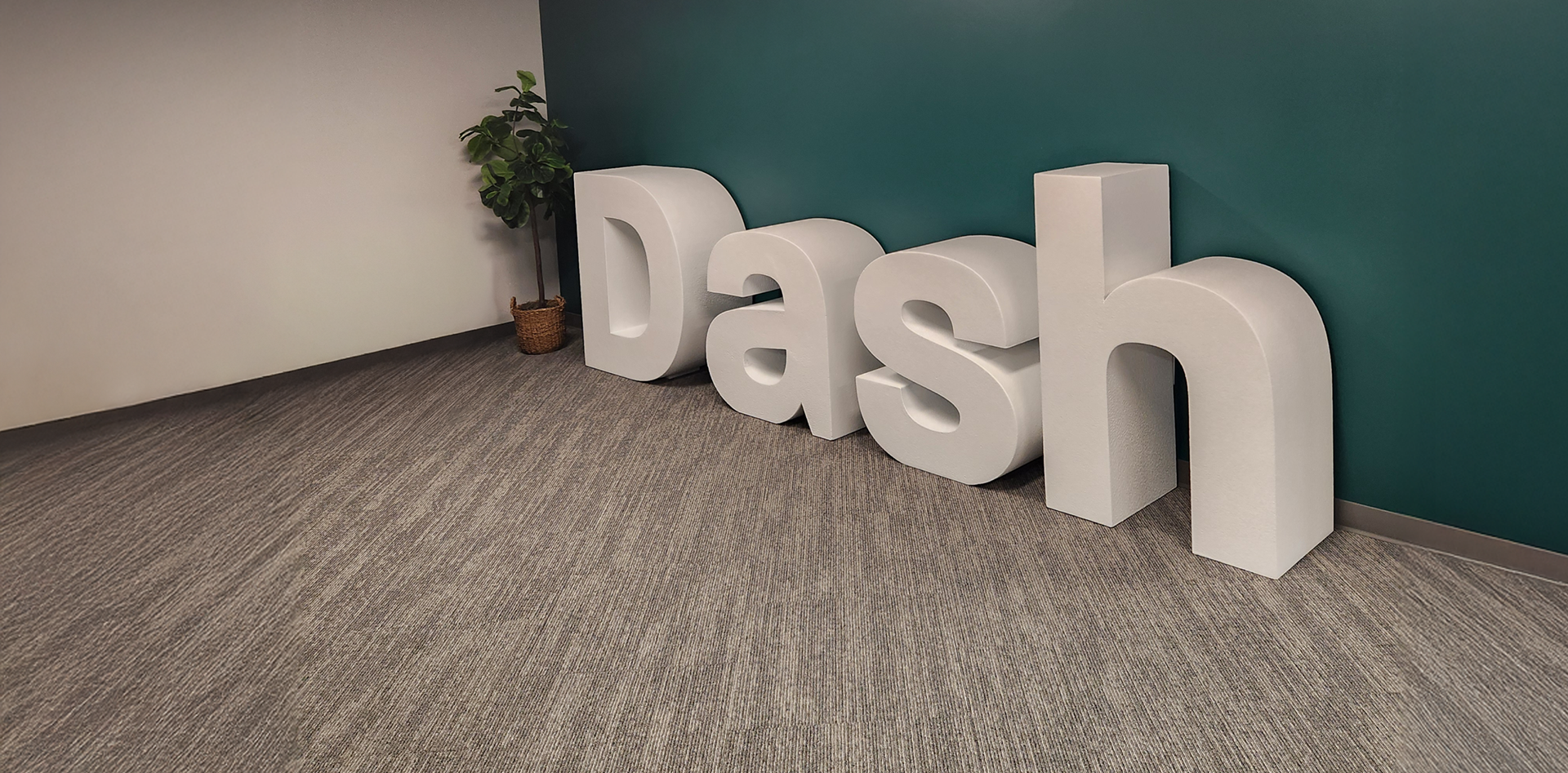 Dash letters lined up against a green wall